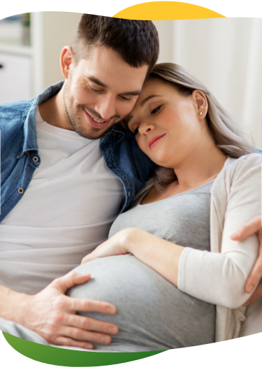 Trudnica koja pati od nadutosti, sjedi na kauču zatvorenih očiju.  Partner je tješi i drži u zagrljaju