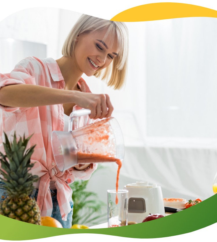 Žena sa plavom kosom i paž frizurom priprema smoothie sa ananasom i raznim voćem